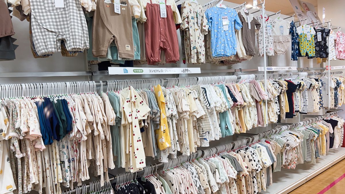 Nishimatsuya baby clothing section with a large rack of rompers and outfits in various sizes