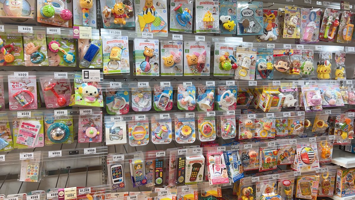 Nishimatsuya toy wall displaying a large selection of baby and toddler toys in bright packaging